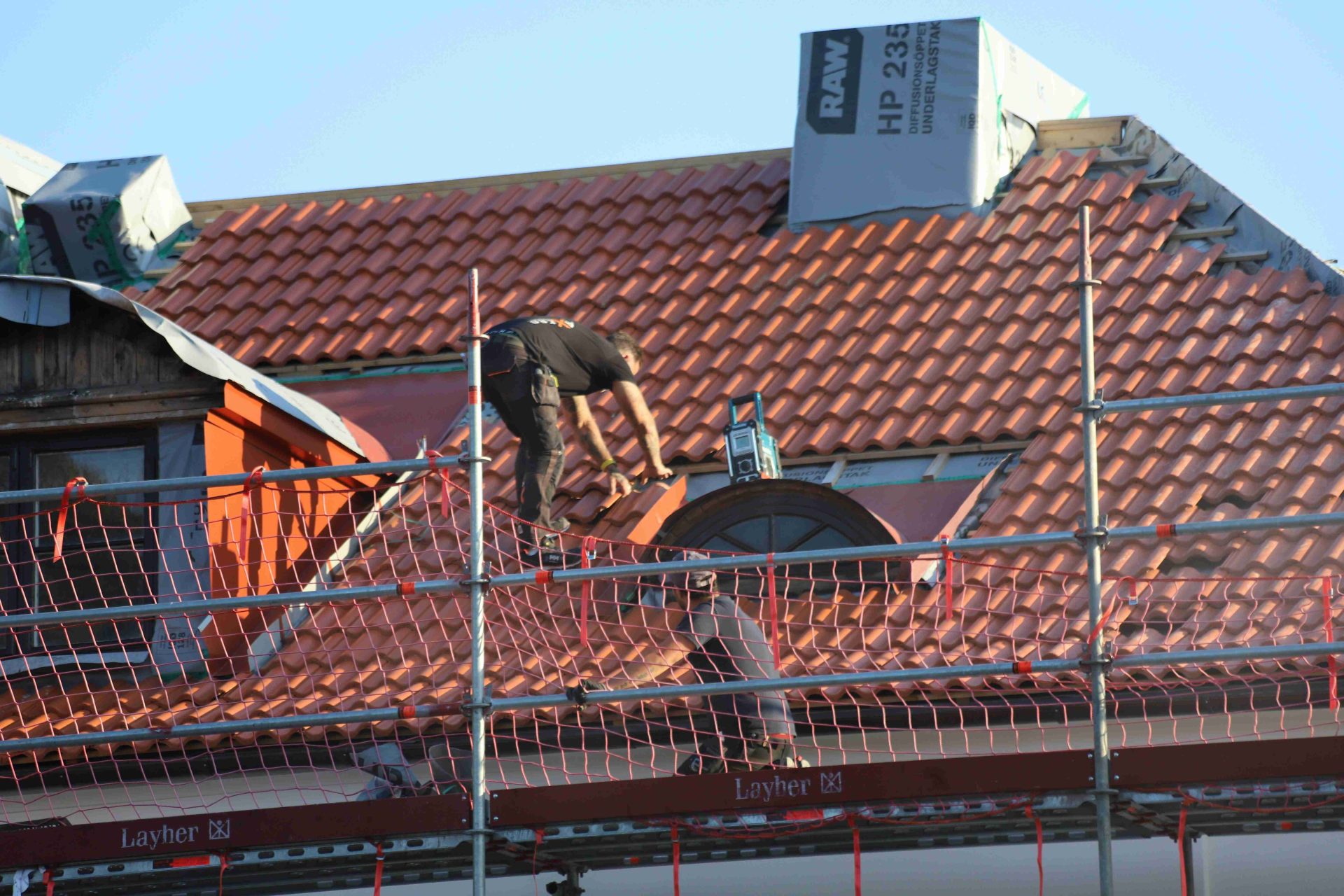 Dachdecker auf einem Gerüst